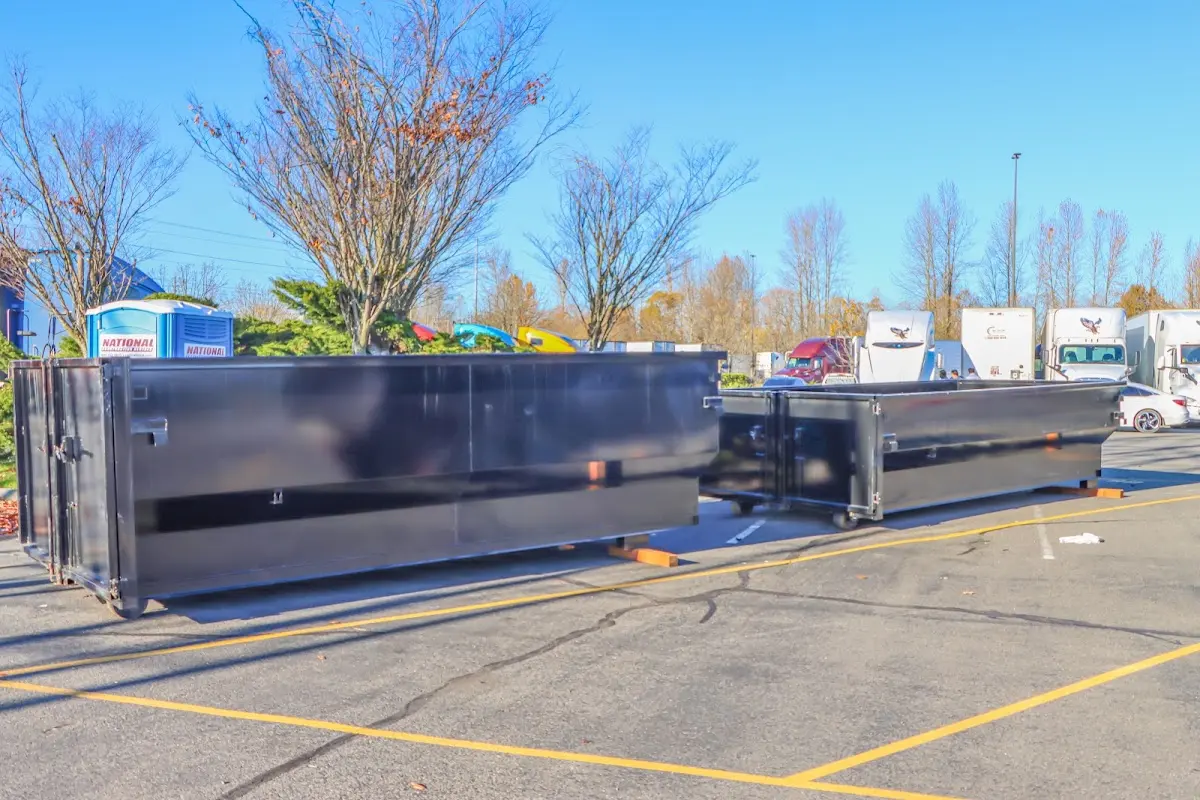 Professional dumpster rental service with roll-off container on residential driveway in Redford